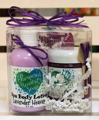 Front of gift pack, clear plastic box with purple bow, travel sized items include purple lotion, purple body polish and full-sized purple soap bar.