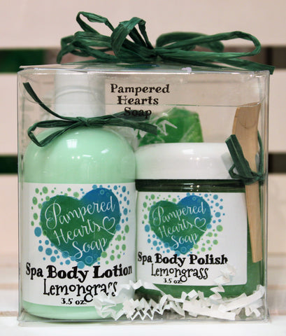 Front of gift pack, clear plastic box with green bow, travel sized items include green lotion, green body polish and full-sized green soap bar.