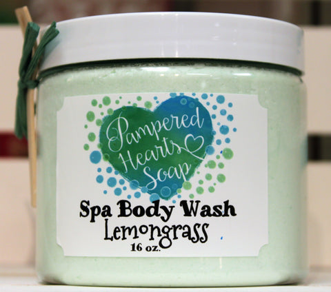 Clear 16 ounce container with white lid, a small wooden scoop and green ribbon. Contains Lemongrass scented whipped body wash, which is colored light green. 