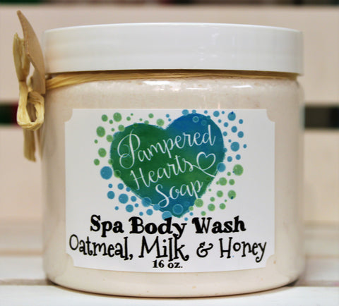 Clear 16 ounce container with white lid, a small wooden scoop and cream colored ribbon. Contains Oatmeal, Milk, and Honey scented whipped body wash, which is cream colored.